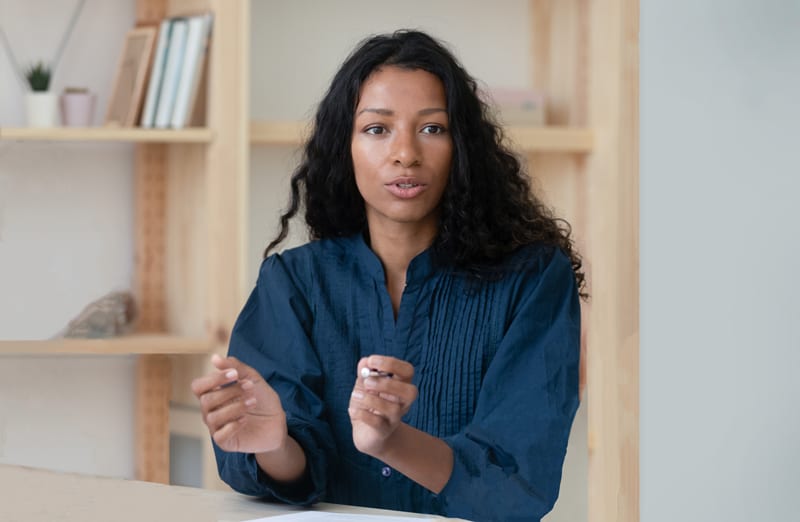 A middle-aged African woman talking at a copywriting course in Singapore.